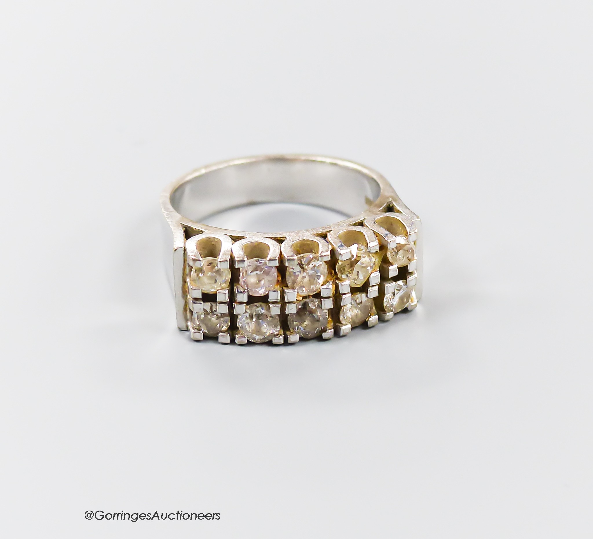 A modern 18ct white metal and ten stone diamond set two row half hoop ring, size O/P, gross weight 13.6 grams.